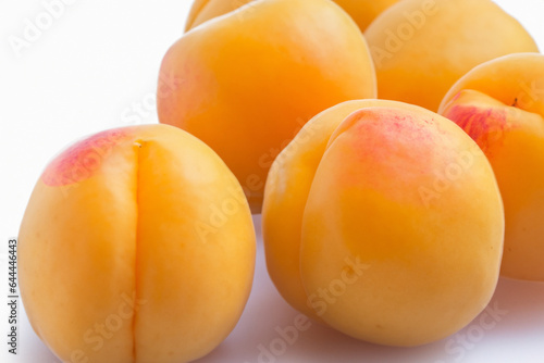 Fresh, ripe apricots on a clean white background, showcasing their natural vibrant color and juicy appeal.