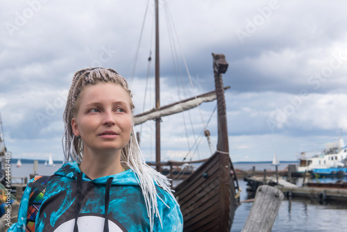 woman tourist went ashore after sailing in a modern replica of anсient viking longship photo
