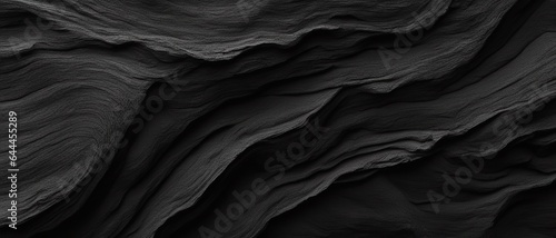 Black volcanic cave rock in the form of overlapping layers, wallpaper