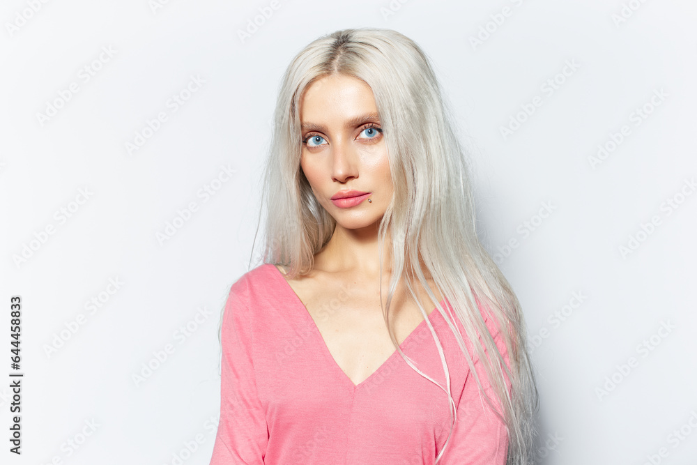 Studio portrait of pretty blonde girl in pink shirt on white background. Studio portrait of pretty blonde girl in pink shirt on white background.