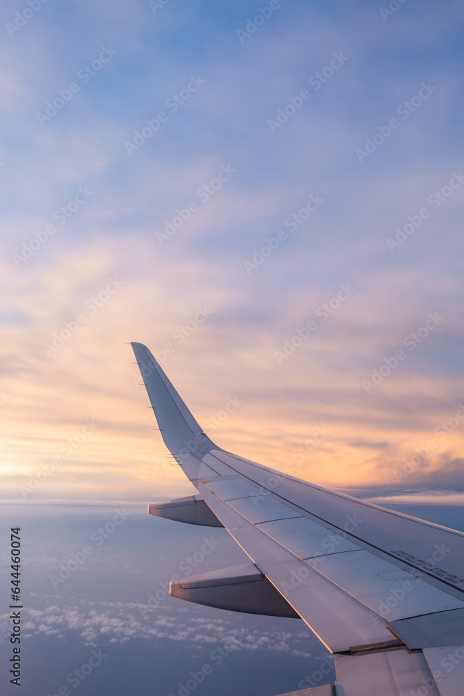 Wing of airplane in colorful cloudscape Wing of airplane in colorful cloudscape