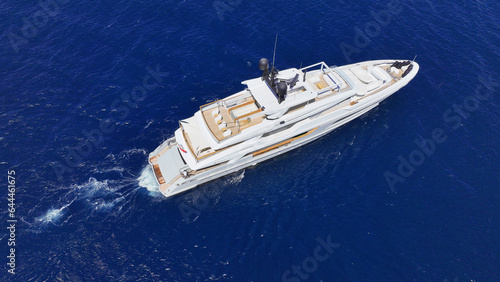 Aerial drone photo of beautiful modern super yacht with wooden deck cruising in low speed deep blue Aegean sea © aerial-drone
