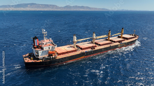 Aerial drone photo of bulk carrier ship carrying heavy merchandise and cruising deep blue open ocean sea