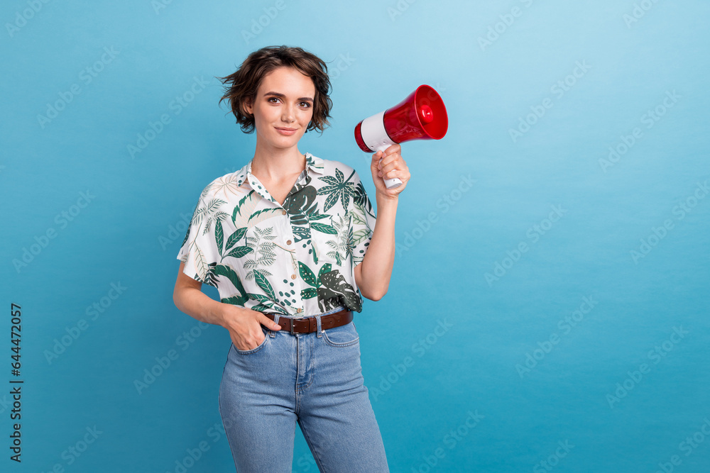 Photo of adorable pretty girl with bob hairstyle dressed colorful blouse arm in pocket hold megaphone isolated on blue color background Photo of adorable pretty girl with bob hairstyle dressed colorful blouse arm in pocket hold megaphone isolated on blue color background