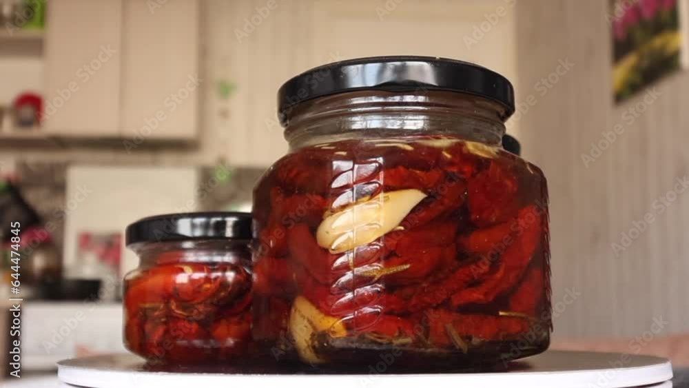 Remated tomatoes in glass jars. Rotates on an electric rotary table. Close-up. Remated tomatoes in glass jars. Rotates on an electric rotary table. Close-up.