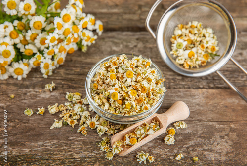 Dry chamomile flowers on a wooden table. Soothing chamomile tea. Herbal drink. flat layout. Space for text.Copy space.Medical prevention and immune concept. Folk alternative medicine.