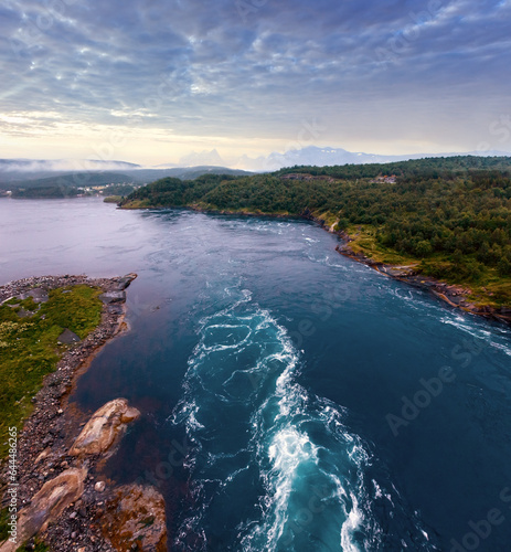 Fjord summer dusk landscape with flowing tidal current water. View from bridge (Norway).