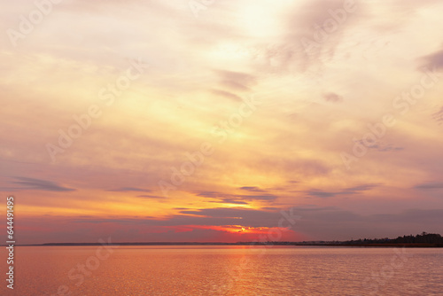 Colorful sky background on sunset  orange blue vivid color clouds and surface water on lake Ik. Nature abstract fon with reflections on water  natural shades cloudscape  nature environment