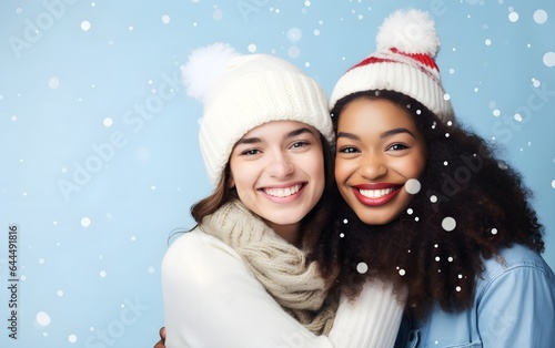 Close view of  happy young multiracial lesbian couple celebrating Christmas hugging in Santa hats, winter, outside on a date, festive blue snowing background, love is love, African American, New year