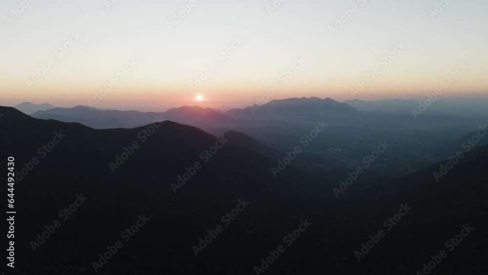 Aerial view of the sun setting down across the valley in Serino along the Mount Terminio with National park, Campania, Avellino, Italy. Aerial view of the sun setting down across the valley in Serino along the Mount Terminio with National park, Campania, Avellino, Italy.