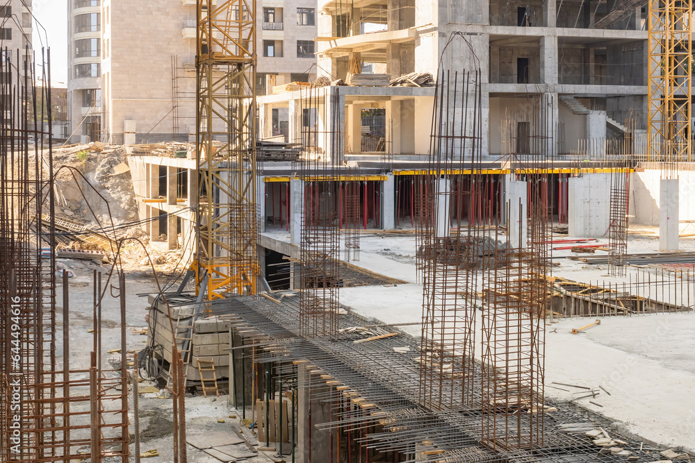 Armature sticking out of building under construction. Process of erection of multi-storey building. Metal armature at construction site. Territory of house under construction. Armature sale concept.