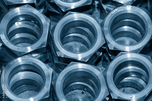 The pile of large size hexagon nut parts in the light blue scene.