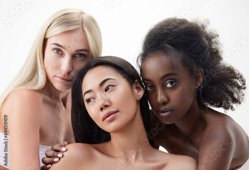 Elegant, attractive young women with different skin color, multiracial models standing against white background. Concept of multi ethnic beauty, natural, spa, cosmetology, wellness, ad