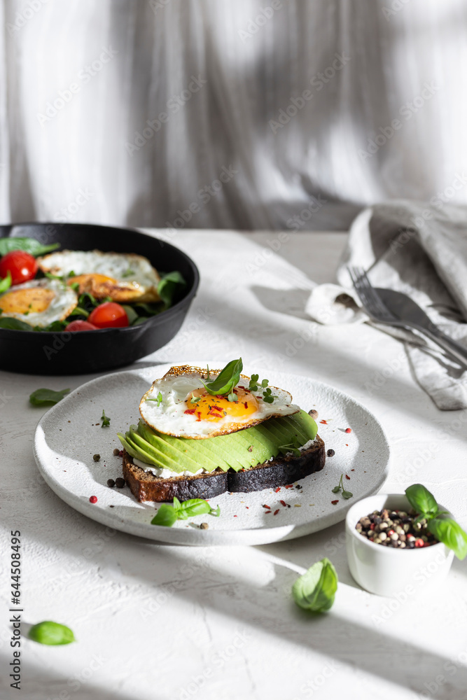 Toasted bread with avocado and fried egg for breakfast Toasted bread with avocado and fried egg for breakfast