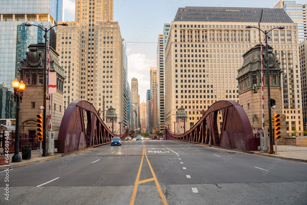 Obraz premium Street over a bascule bridge spanning Chicago river at sunset in spring