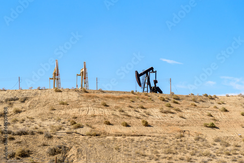 Oil wells at the top of a desert hillin California  on a clear autumn day