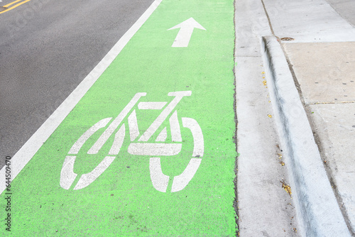 Φωτογραφία Empty green coloured bicycle lane runnig along a street in a downtown district