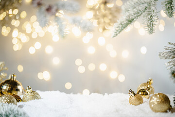 Christmas Holiday background with snow, fir tree and decorations with christmas light behind