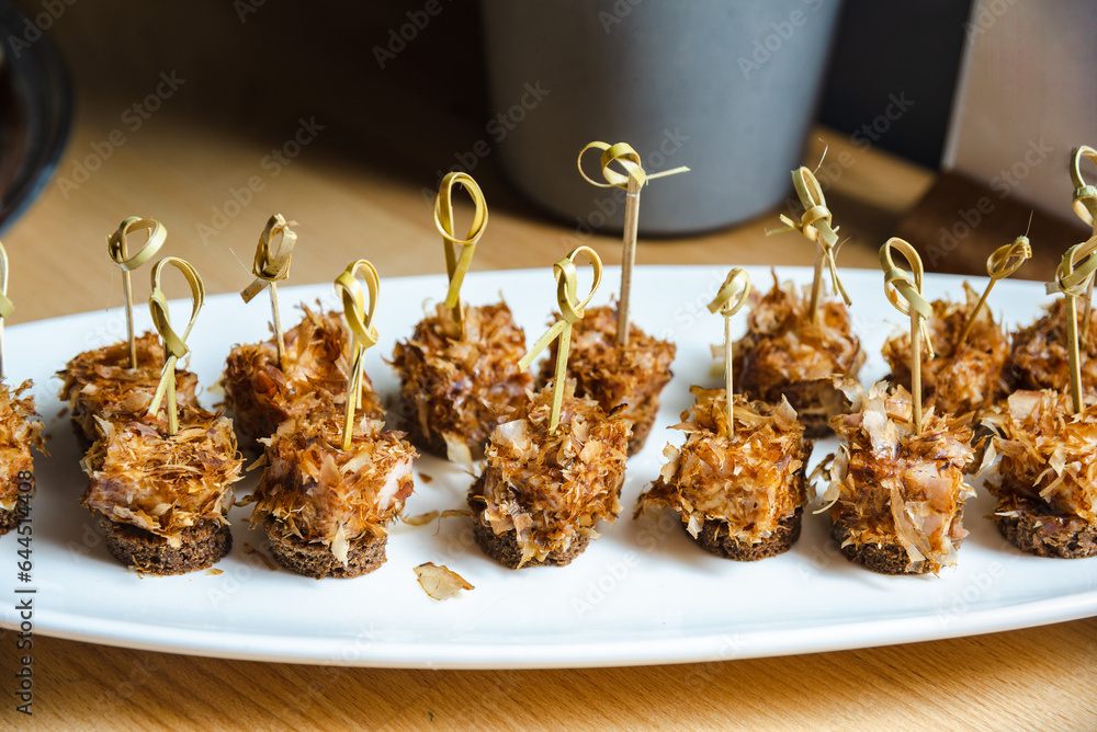Obraz na plátně Tuna flakes canapes on a white plate on a wooden table