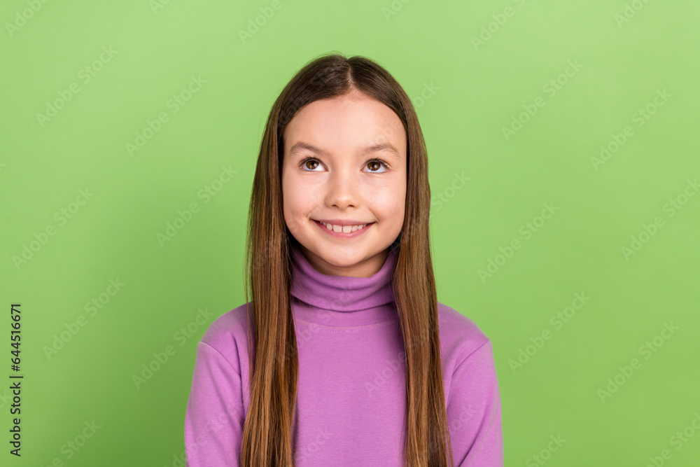 Photo of cheerful small girl with straight hairdo wear purple turtleneck look up at empty space offer isolated on green color background Photo of cheerful small girl with straight hairdo wear purple turtleneck look up at empty space offer isolated on green color background