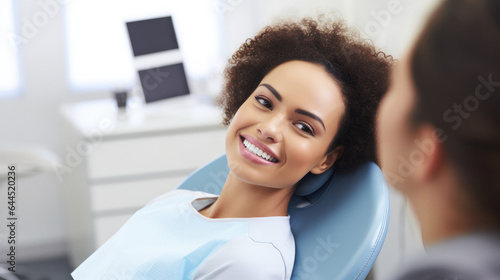 A mixed individual sitting and smiling in a dentist's office, radiating comfort and confidence in healthcare settings. Free Download A mixed individual sitting and smiling in a dentist's office, radiating comfort and confidence in healthcare settings. - GFXLoad