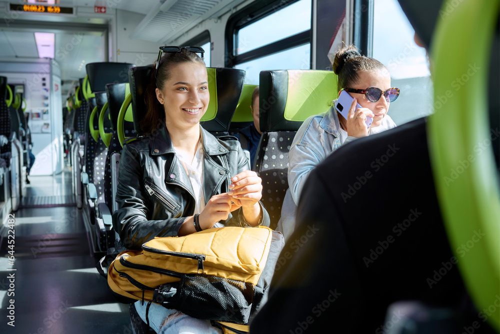 Commuter train passengers, young student girl with backpack goes to study Commuter train passengers, young student girl with backpack goes to study
