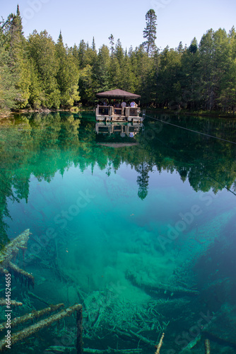 Turquoise clear waters at Kitch-iti-kipi spring in Michigan's Upper Peninsula, visitor viewing raft © Stefanie