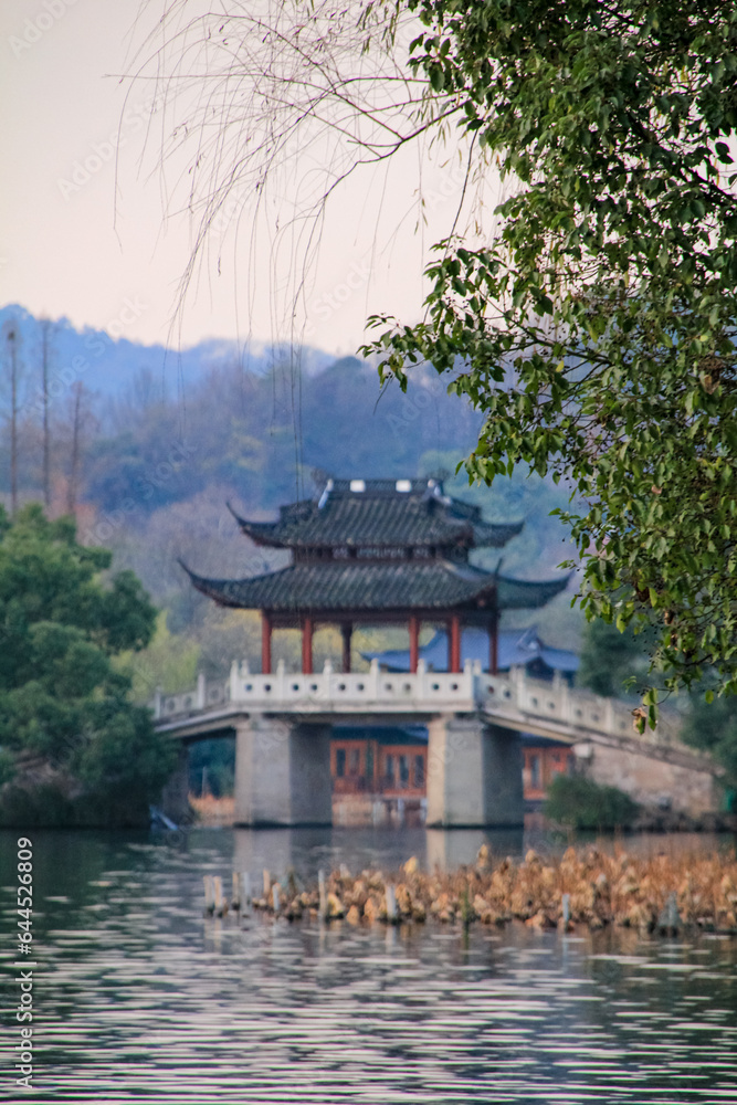 Famous pavilion bridge in West Lake, Hangzhou, China. West Lake Jade Belt Bridge with trees. Travel and nature scene. Popular park of Hangzhou city China. 