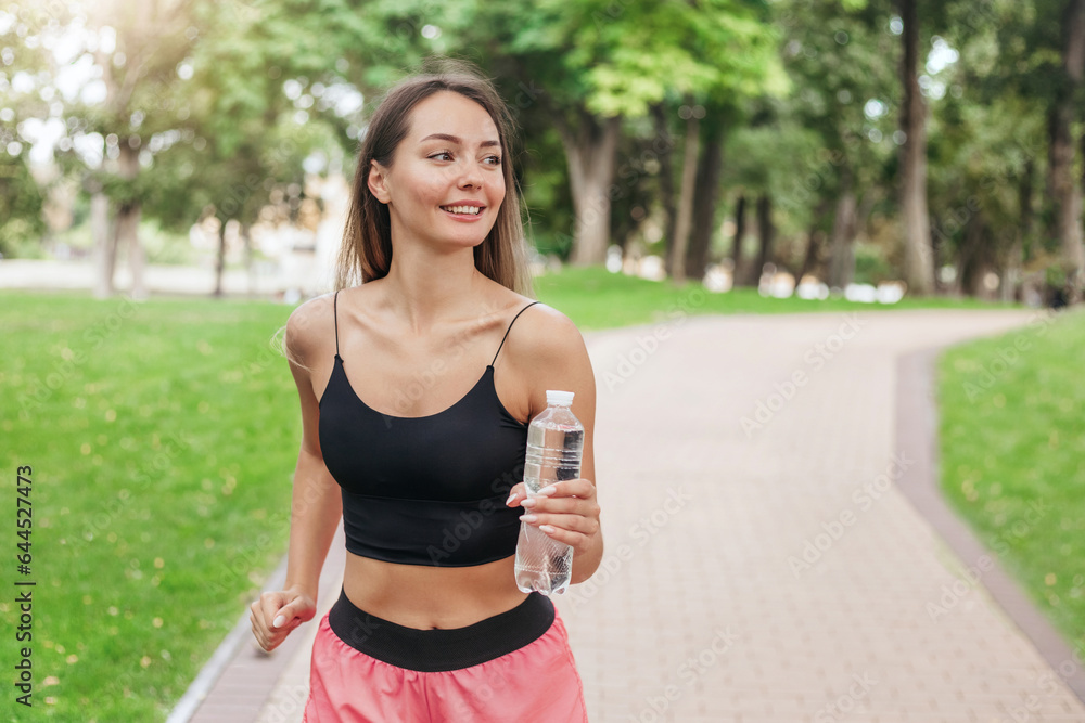 girl on a morning run with a bottle of water in the park girl on a morning run with a bottle of water in the park
