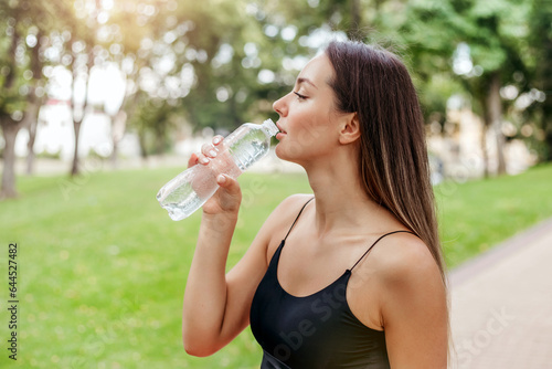 sports girl jogging in the park and drinking water
