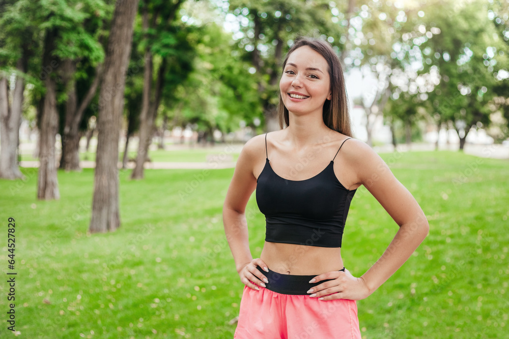 Sports girl stands in the park and smiles. copy space Sports girl stands in the park and smiles. copy space