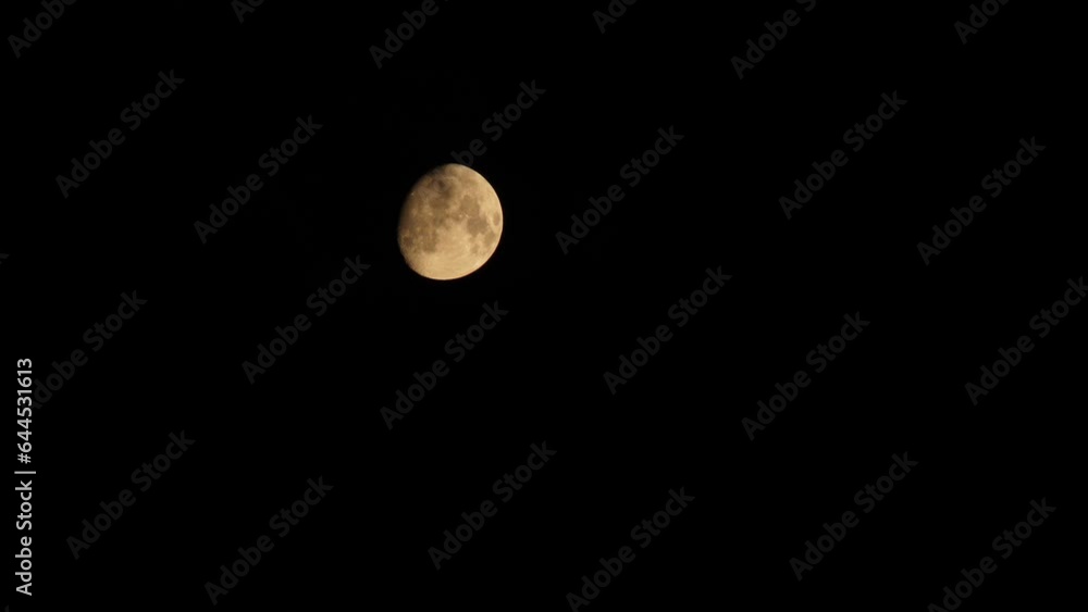 Clear moon and black clouds. The partly clear moon is setting down. Black clouds float against the backdrop of the yellow moon with craters. 4k footage video. Close-up. Natural satellite of Earth Clear moon and black clouds. The partly clear moon is setting down. Black clouds float against the backdrop of the yellow moon with craters. 4k footage video. Close-up. Natural satellite of Earth