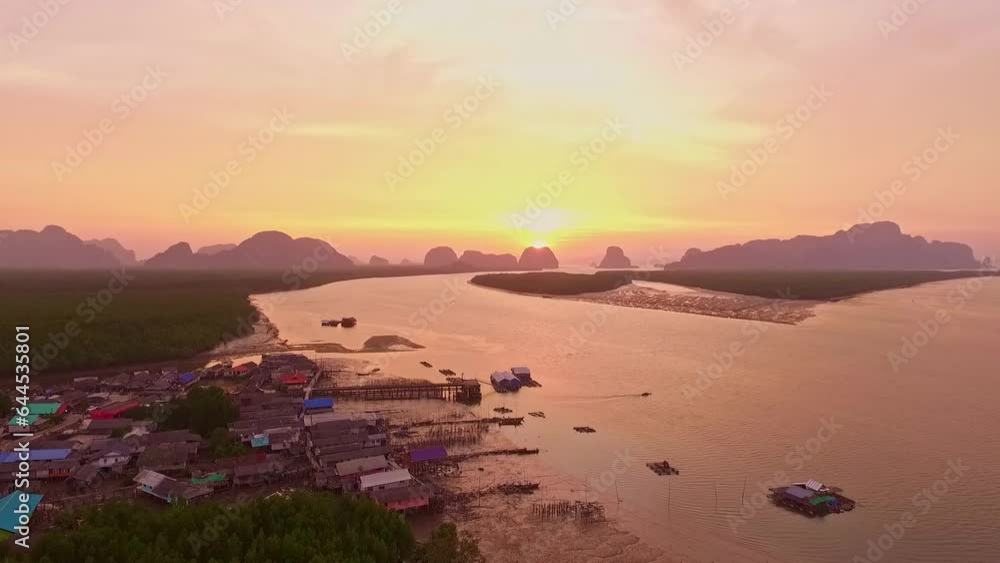 Aerial view amazing golden sunrise above pier at Ban Sam Chong fishing village.yellow reflections shimmer on the surface of the sea at sunrise. .creating a beautiful shimmering effect. Aerial view amazing golden sunrise above pier at Ban Sam Chong fishing village.yellow reflections shimmer on the surface of the sea at sunrise. .creating a beautiful shimmering effect.