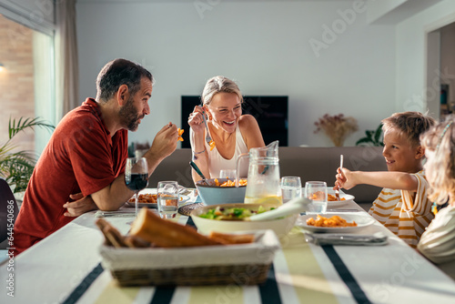 Tableau sur toile Beautiful kind family talking while eating together in the kitchen at home