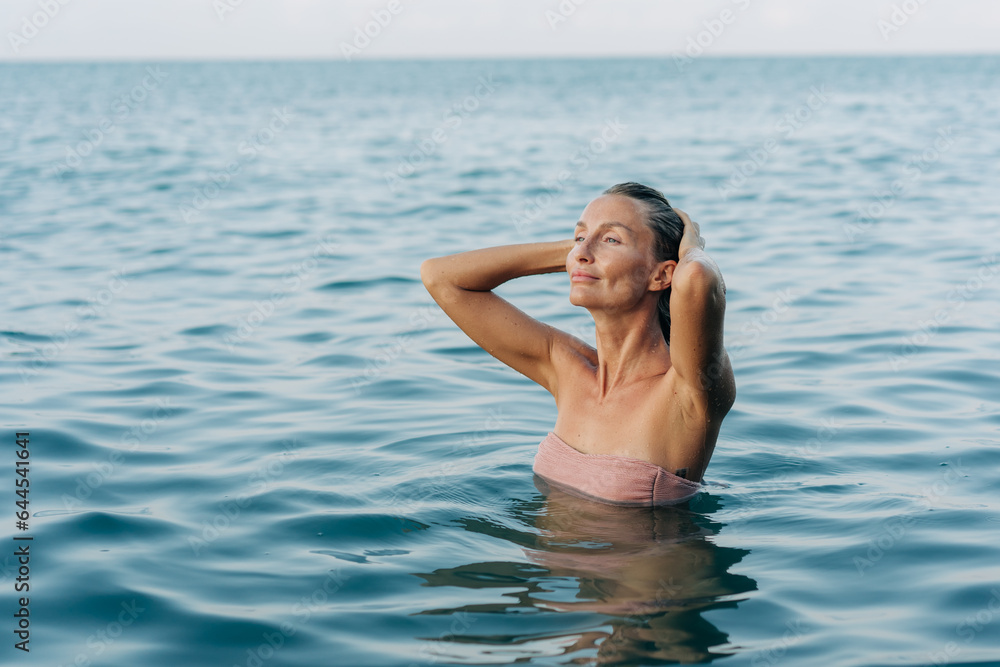 Blissful woman swimming in the sea in pleasure.