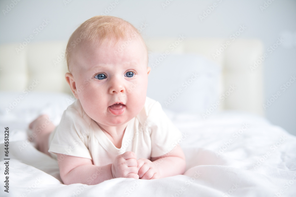 cute smiling baby lying on tummy on parent bed cute smiling baby lying on tummy on parent bed