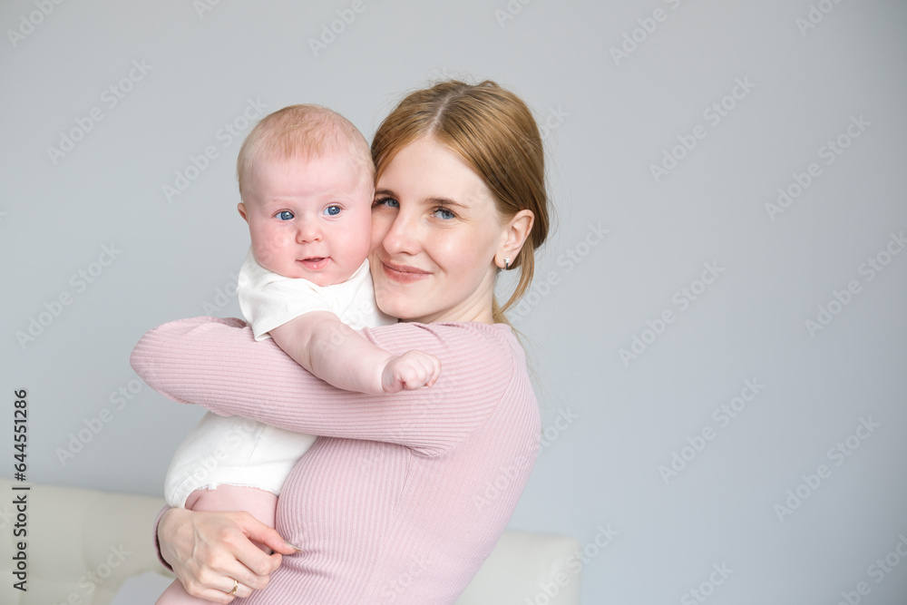 young mother holds her smiling baby in her arms at home young mother holds her smiling baby in her arms at home