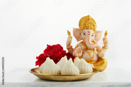 Idol of lord Ganesha with Modak Sweet Dish and flower. Ganesh chaturthi photo