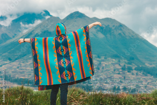 Model wearing a poncho handmade with sheep cloth by the indigenous Kichwa artisan communities of the area, posing at the San Pablo lake in Otavalo, Ecuador. photo