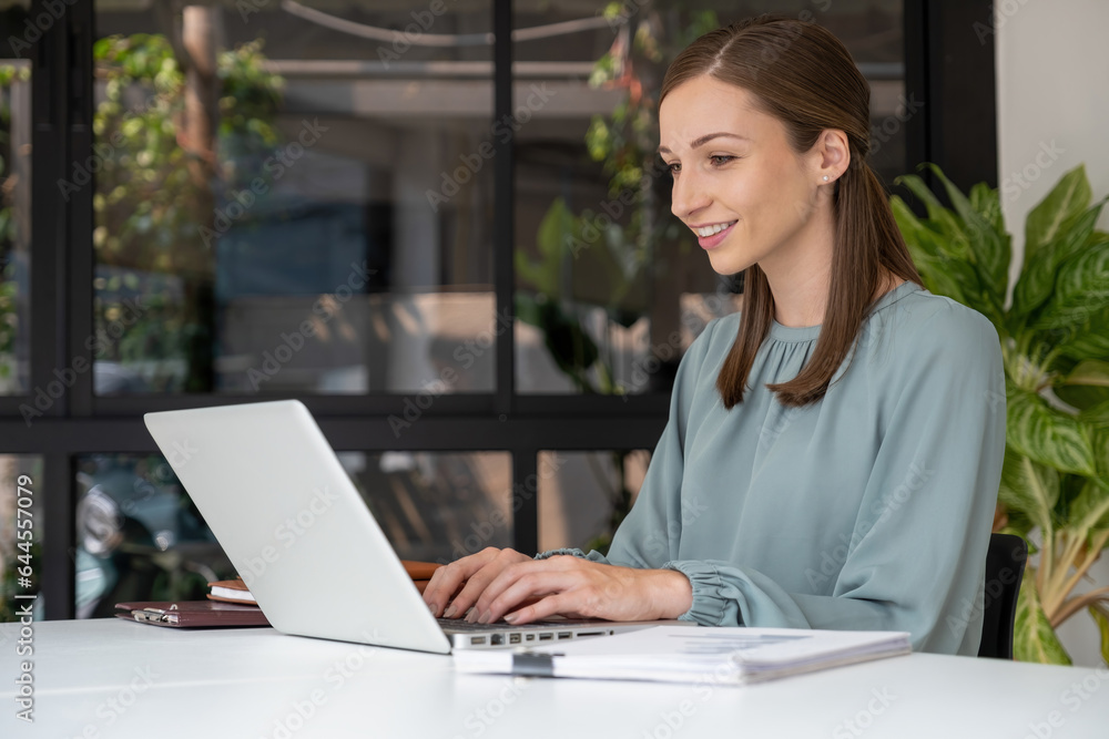 Businesswoman working at desk using laptop. Businesswoman working at desk using laptop.