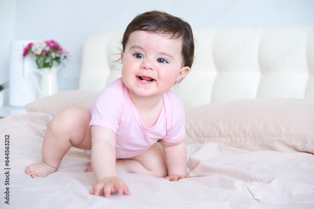 portrait of smiling healthy baby in pink bodysuit on bed portrait of smiling healthy baby in pink bodysuit on bed