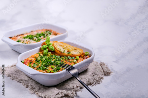 Oven baked frittata with mediterranen vegetables such as zucchini, tomatoes, bell peppers and red onions. Served in a rustic cast.Horizontal photo, space for text