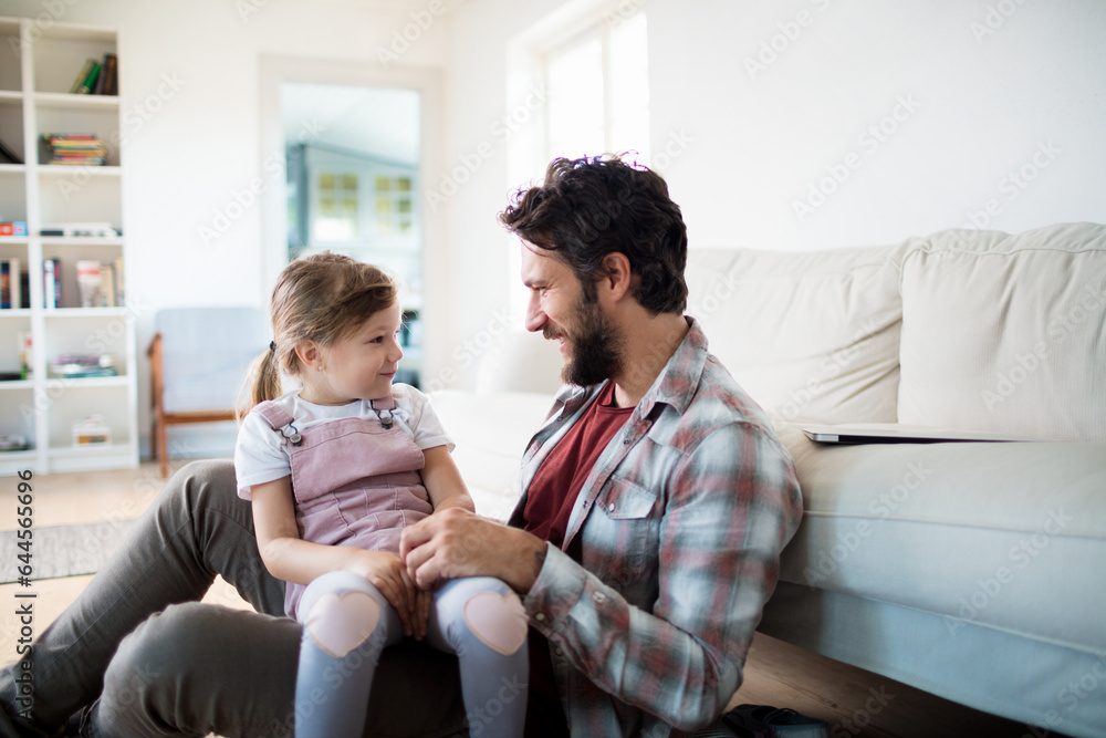 Young father playing with his daughter in the living room at home Young father playing with his daughter in the living room at home