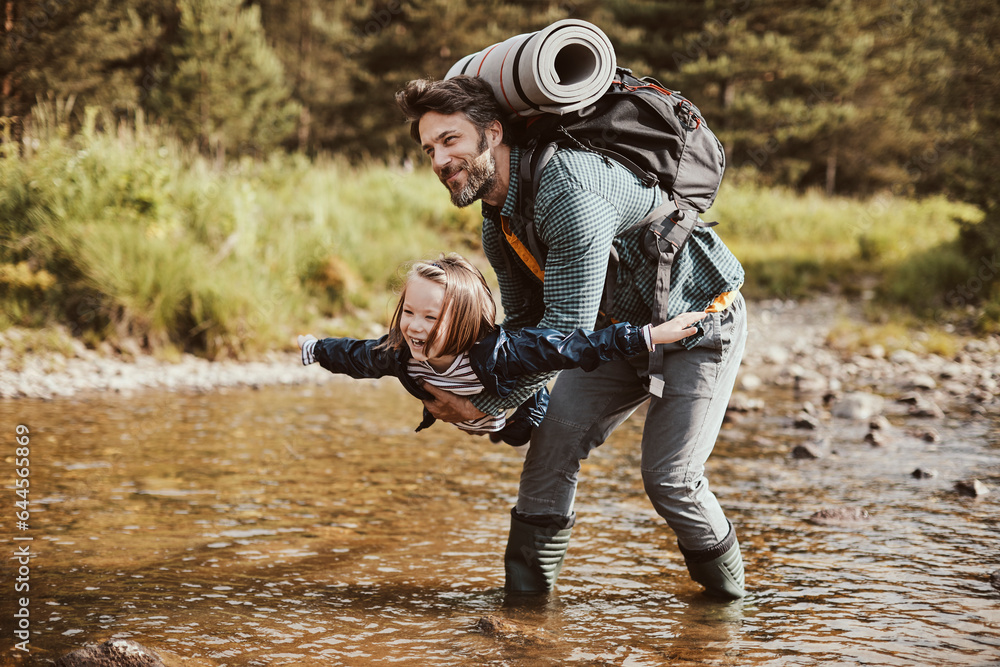 Young father hiking with his daughter in a forest