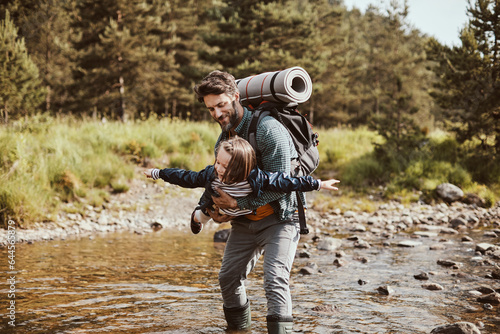 Young father hiking with his daughter in a forest
