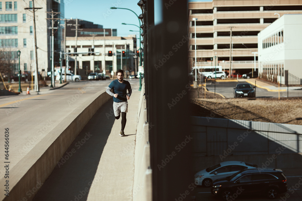 Young man running and exercising on a bridge in the City