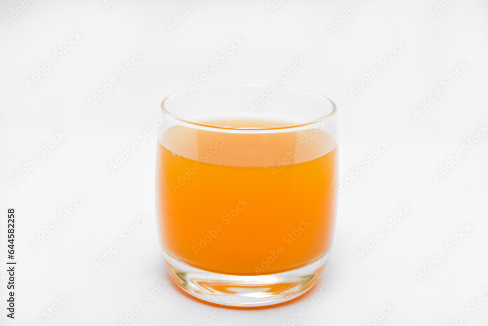 Glass glasses with orange juice on a white background. Delicious orange cooling drink. Glass glasses with orange juice on a white background. Delicious orange cooling drink.