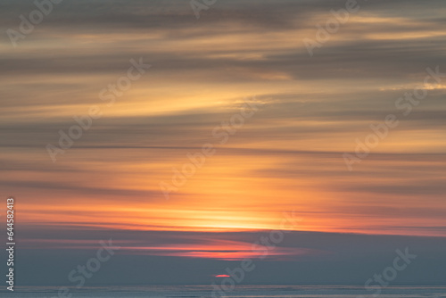 Winter sunrise over the sea in a cloudy sky. © Konstantin