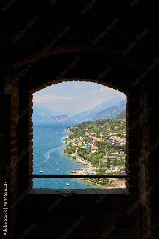 Blick durch ein Fenster auf die Küste des Gardasees bei Malcesine in Italien