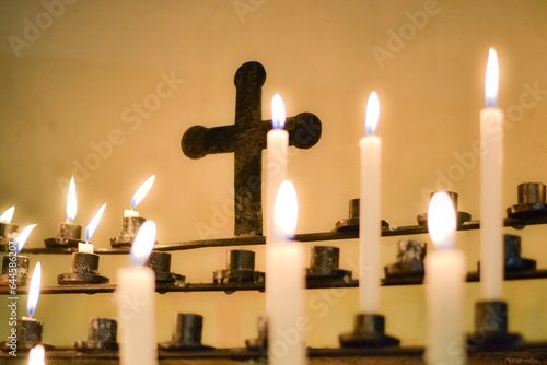 Fotografia Velas en iglesia y una cruz en el fondo